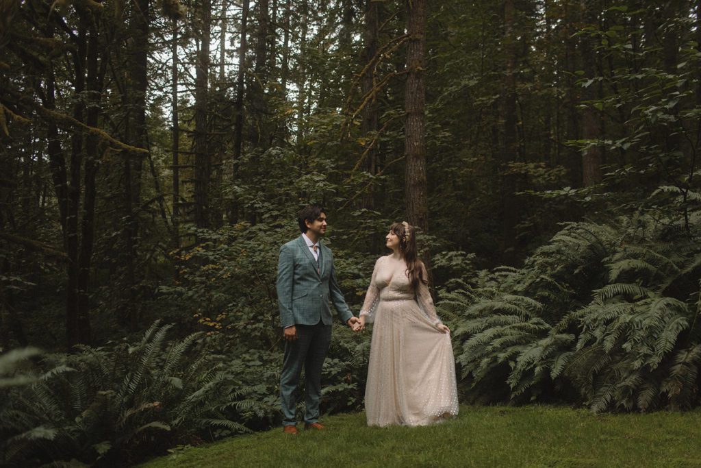 Couple pose in forest on wedding day