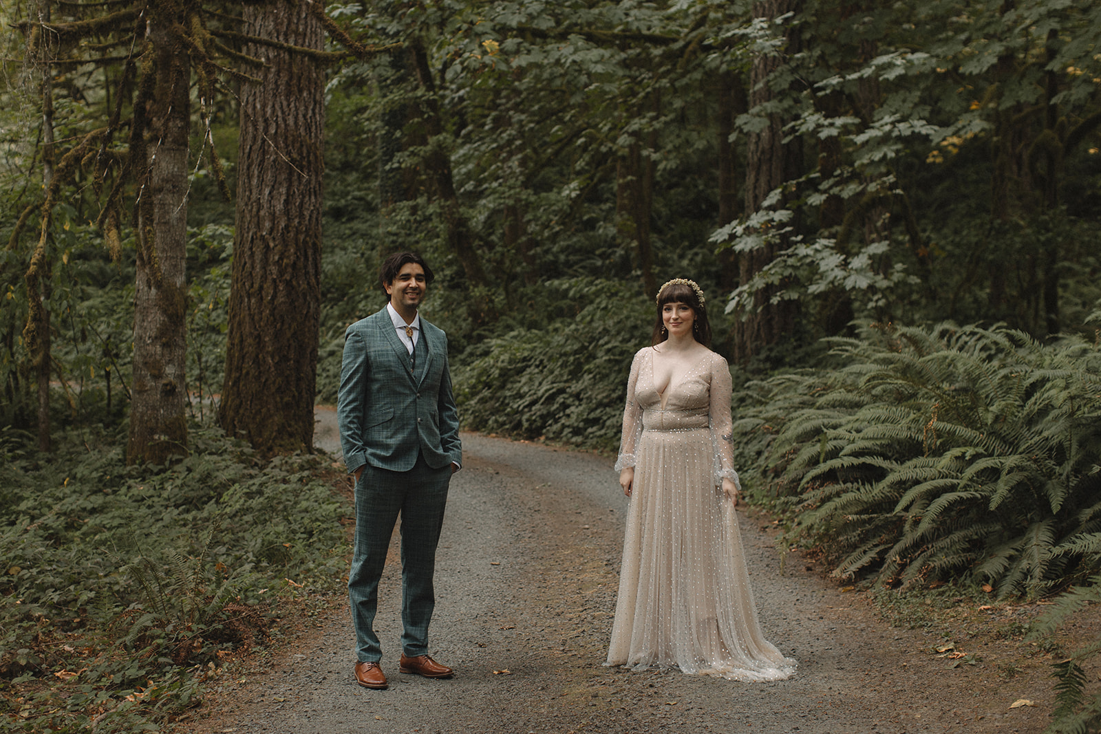 Bride and groom stand in forest at Dancing Deer Mountain.