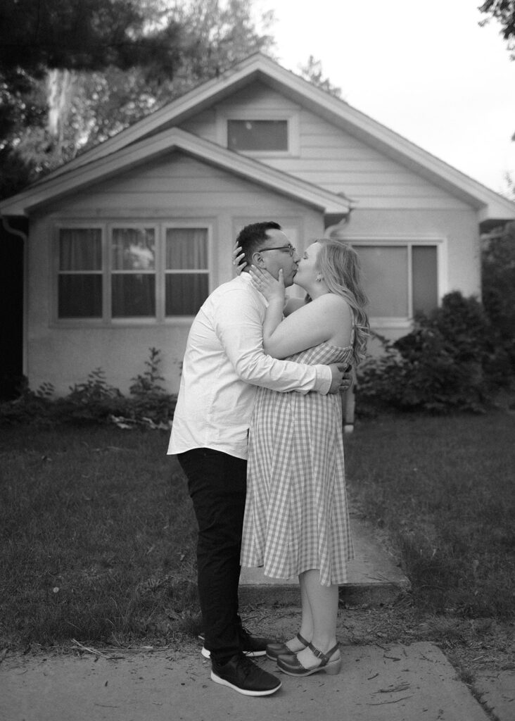 Couple kisses at neighborhood engagement session.