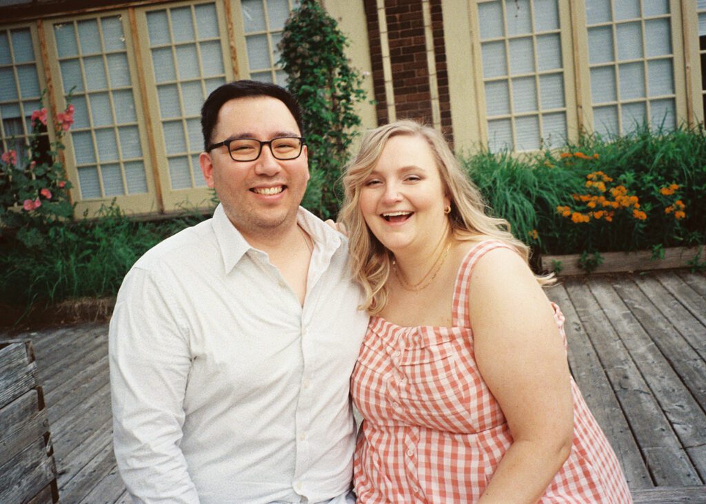 Couple laughs at the camera, at neighborhood engagement session.