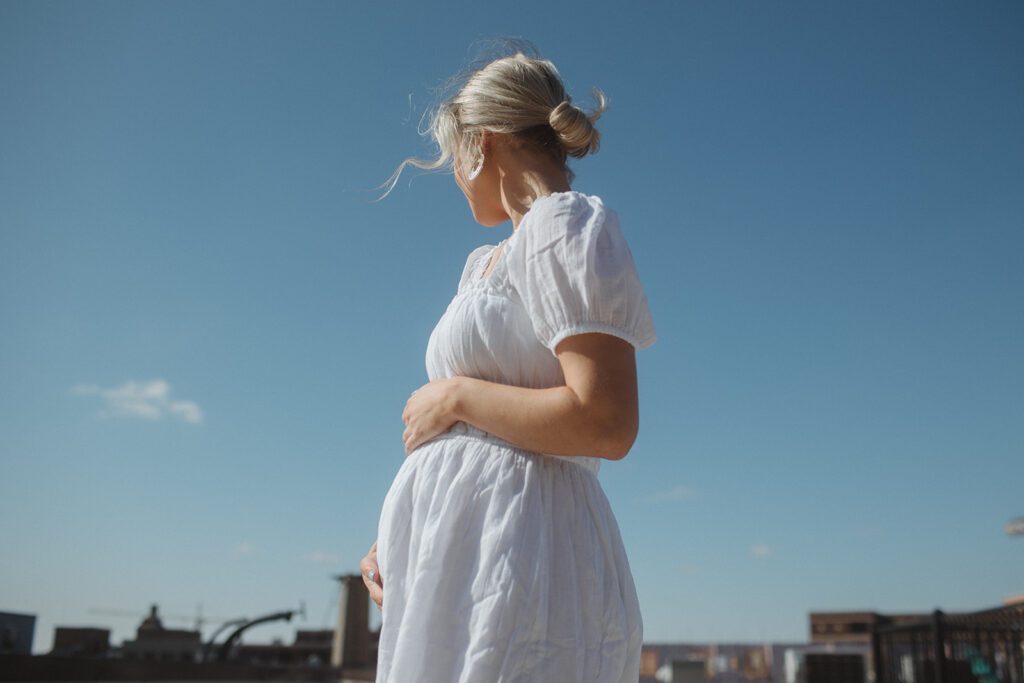 Cally holds her belly at home maternity session.